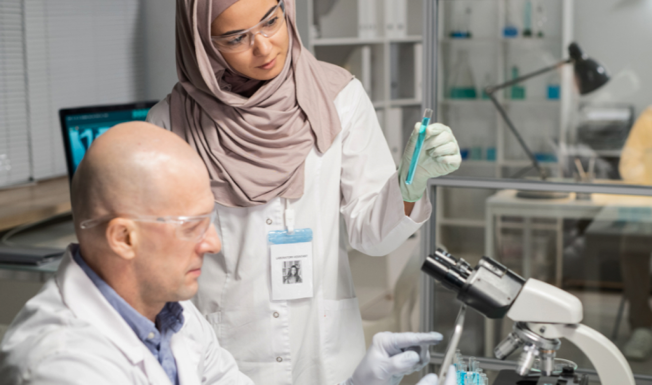 female clinician with flask communicating with colleague